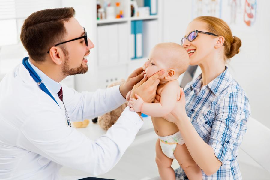 Physician performing oral exam on baby